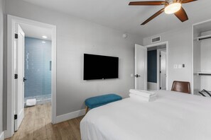 A hotel room with a bed, a television, a ceiling fan, and a bathroom with blue tiles. - Scottsdale Retreat with Private Pool | 4BR Home Near Old Town (Scottsdale)