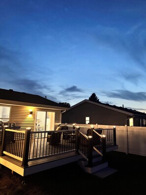 A residential deck with a railing, a staircase, and a barbecue grill. - Stateline Family Retreat  (South Beloit)