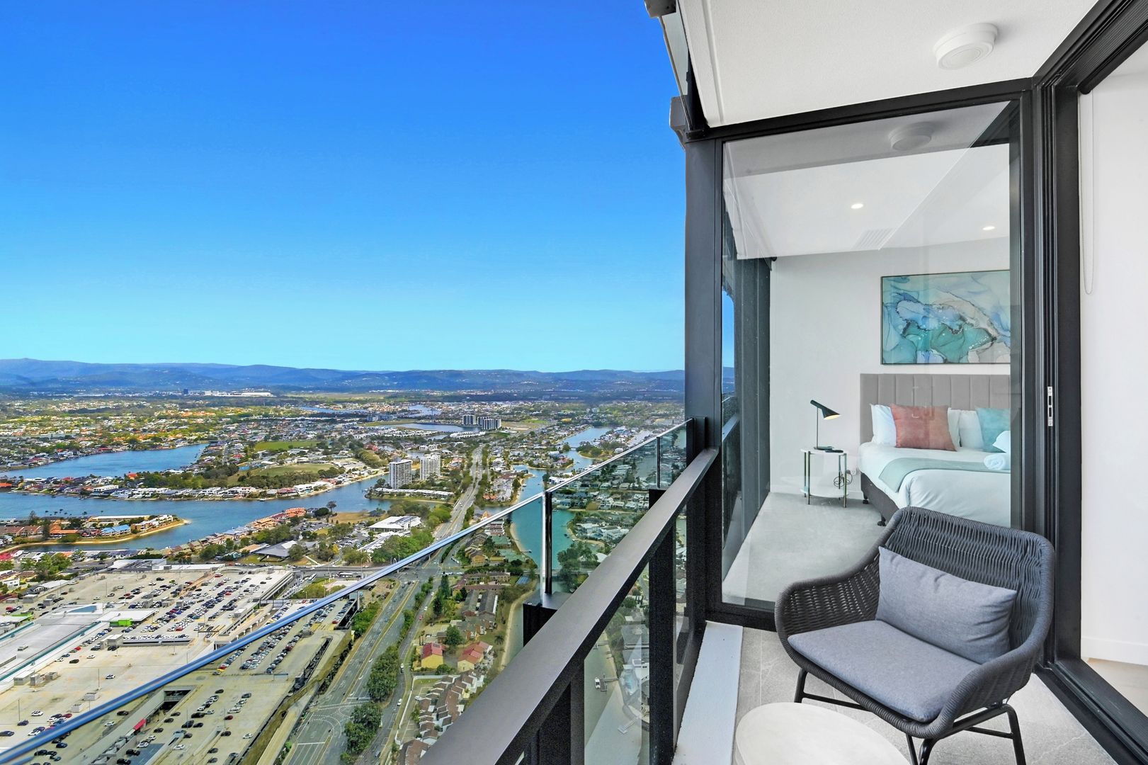A balcony with a city view, a bed, and a chair.