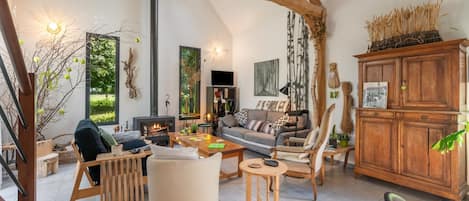 A spacious living room with a fireplace, comfortable seating, and a view of the outdoors.
