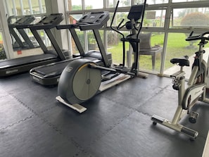 A gym with treadmills, an elliptical, and a stationary bike.