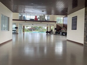 A spacious indoor area with a pool, a staircase, and a view of the outside.