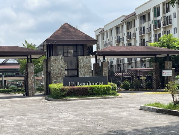 A gated entrance to a residential complex with a sign reading 'Hi Residences.'