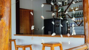 A bar area with wooden furniture and a hanging decoration of white shells.