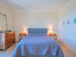 A bedroom with a bed, two bedside tables, a dresser, and a wall with framed pictures. - GRIMAUD VILLA  WITH AN AMAZING SEAVIEW AND SWIMMING POOL (GRIMAUD)