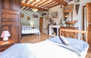 A room with a bed, a wooden headboard, a fireplace, and nautical-themed decorations. - Authentique proche plage D-Day (COURSEULLES-SUR-MER)