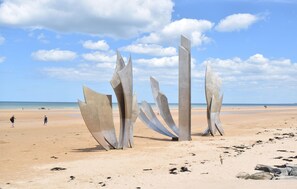 A beach with abstract metal sculptures and a clear sky. - Authentique proche plage D-Day (COURSEULLES-SUR-MER)