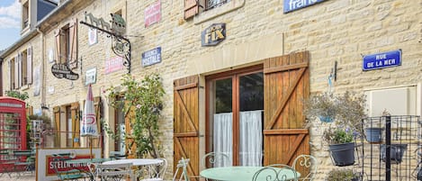 Una calle europea pintoresca con un hotel llamado 'Stella Artois' y un restaurante 'Byrrh'.