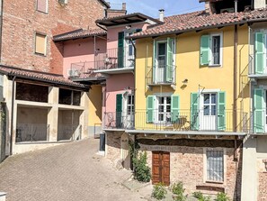 Eine enge Straße mit Gebäuden, die Balkone und Fensterläden zeigen.