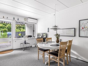 A modern dining area with a round table, chairs, a lamp, and a pendant light.