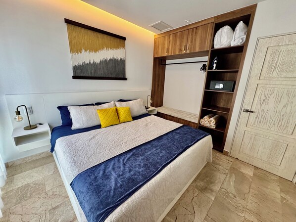 A bedroom with a bed, bedside tables, a wardrobe, and a wall-mounted artwork. - The Best Place in Playa del Carmen! (Playa del Carmen)