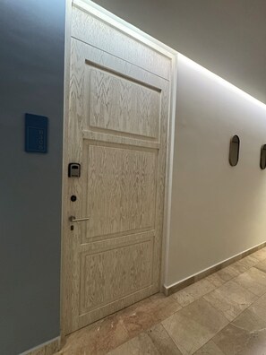 A hallway with a wooden door, a blue sign with numbers, and a light strip above the door. - The Best Place in Playa del Carmen! (Playa del Carmen)