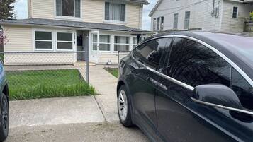 A residential driveway with a parked car and a house with a garage door.