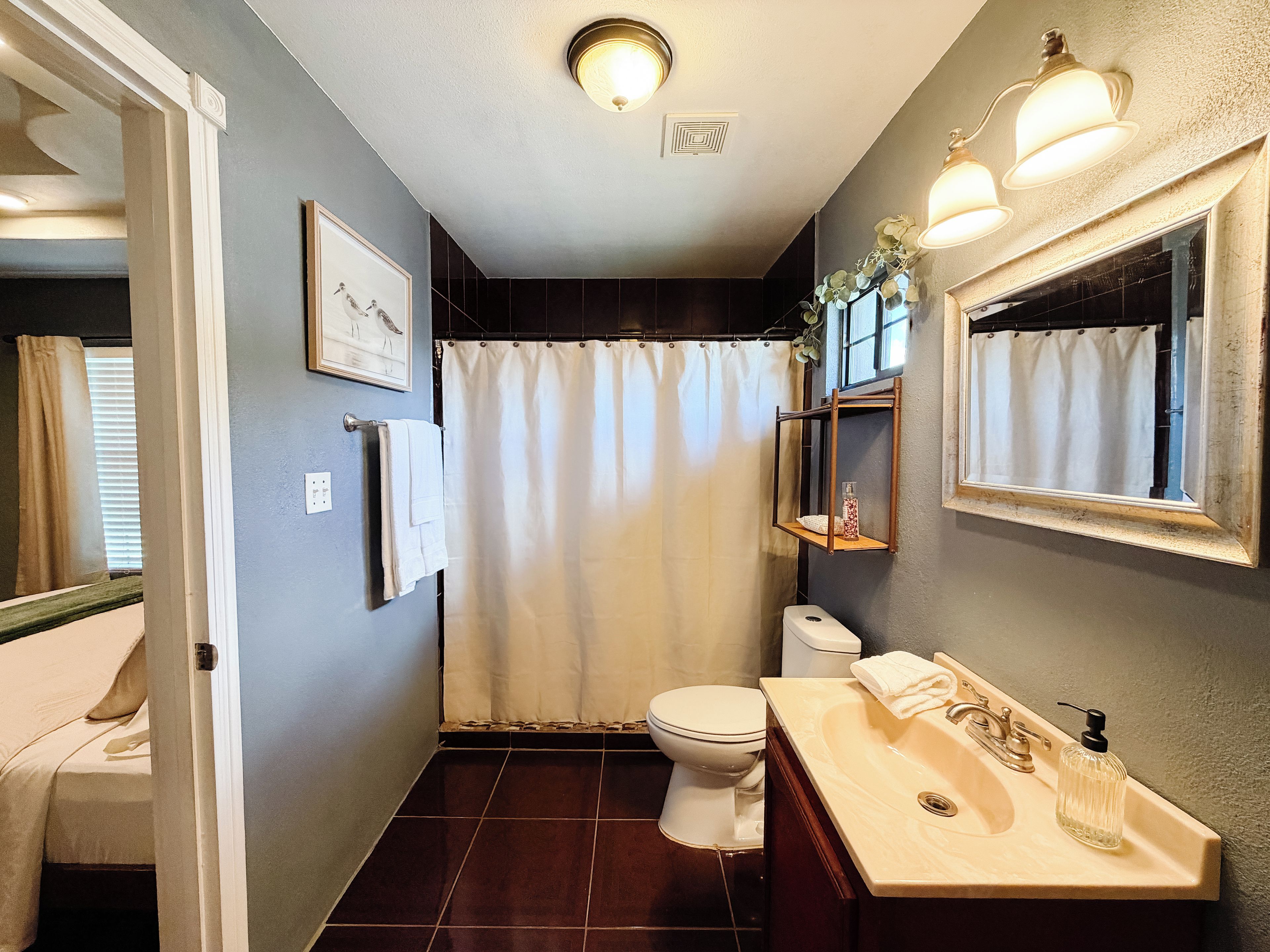 Un baño con inodoro, lavabo y cortina de ducha.