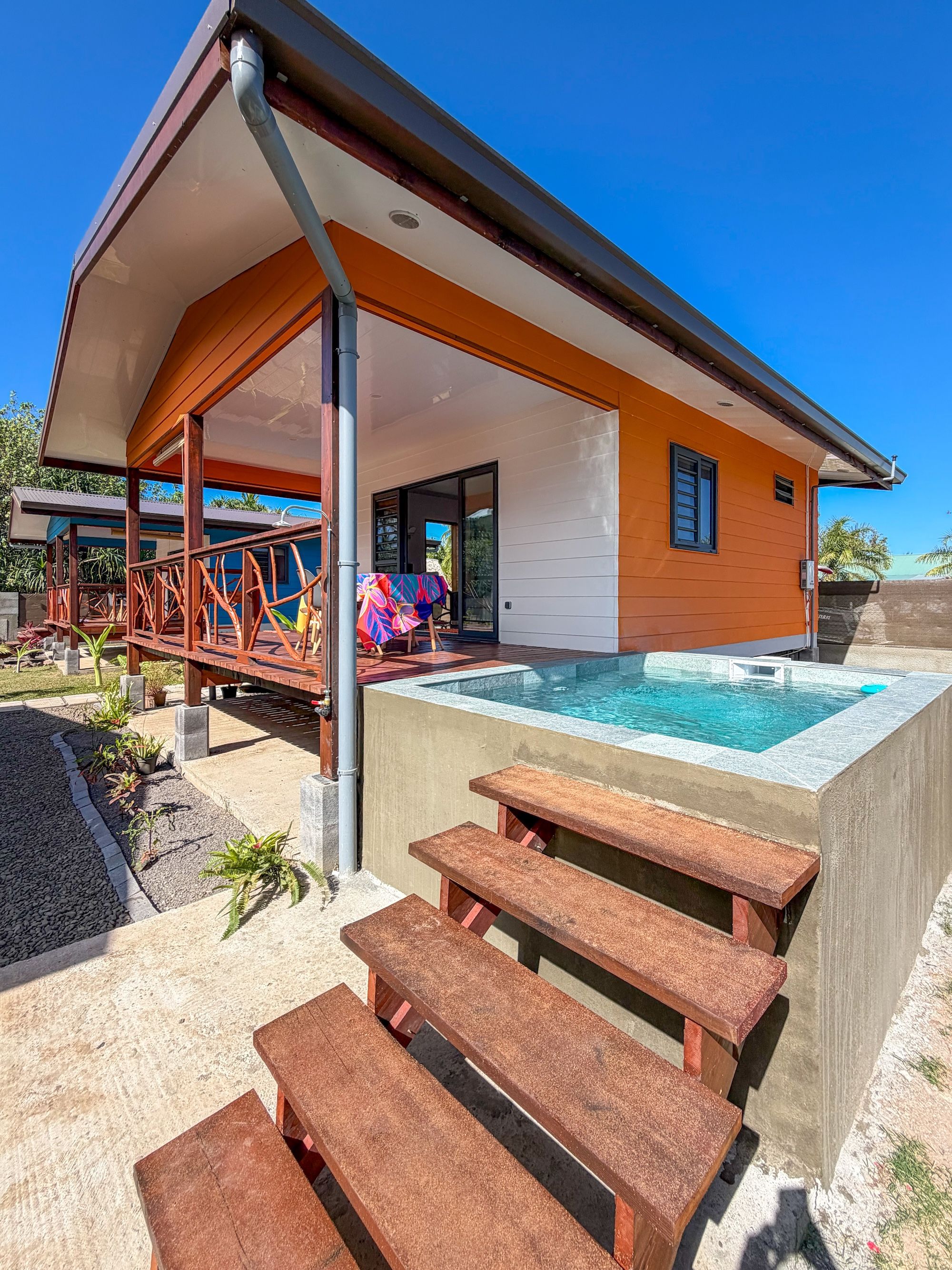 Une maison moderne dotée d’une piscine, d’un espace salon extérieur et d’un patio couvert.