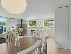 A modern kitchen with a central island, white cabinetry, and a built-in stove. - "Trineke" - 400m from the sea by Interhome (Dannemare)