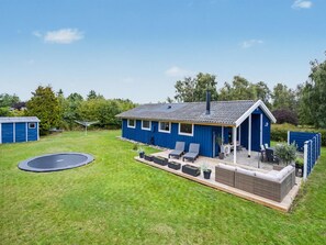 A blue house with a patio, a trampoline, and a covered outdoor seating area. - "Trineke" - 400m from the sea by Interhome (Dannemare)