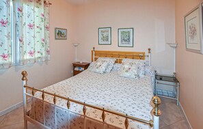 A bedroom with a bed, nightstands, and framed pictures on the wall. - Maison avec piscine privée (Vaison-la-Romaine)