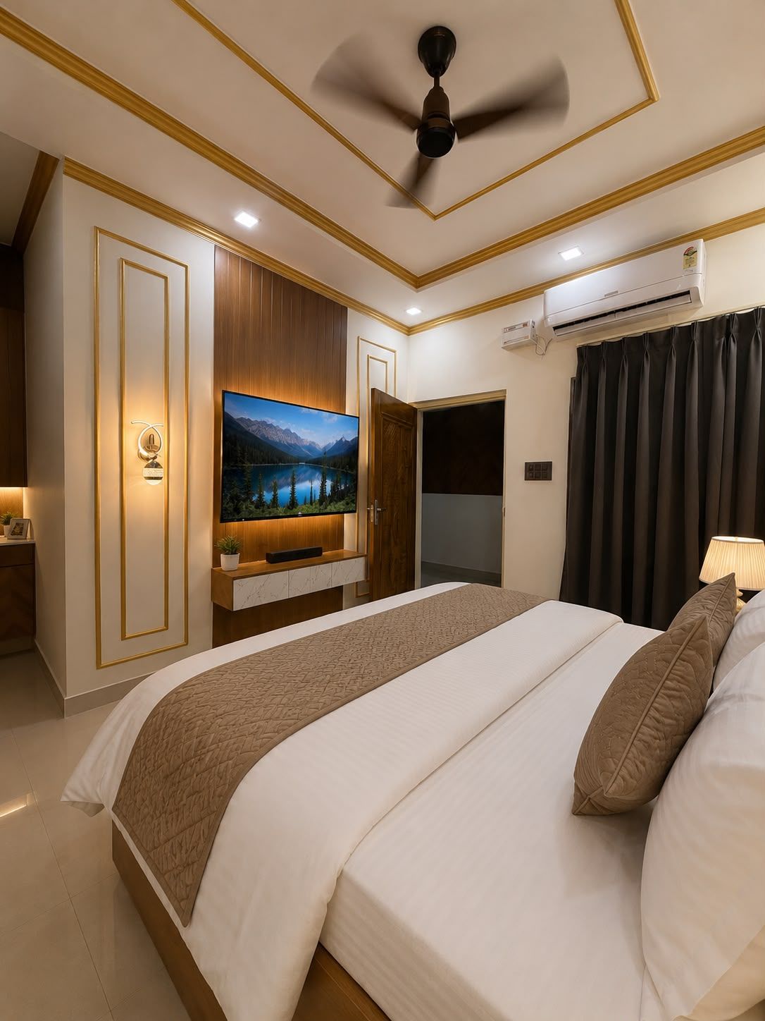 A bedroom with a bed, a ceiling fan, an air conditioning unit, a wall-mounted TV, and a door leading to another room.