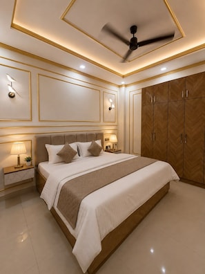 Quarto com uma cama grande, luminárias laterais, ventoinha no teto e armários de madeira.