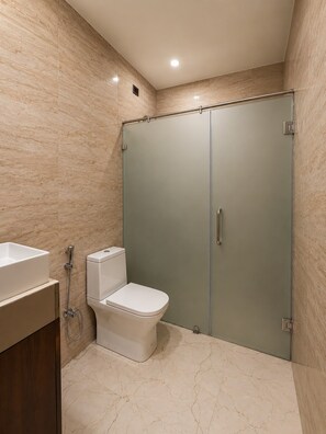 Uma casa de banho moderna com sanita, bidé e zona de duche.