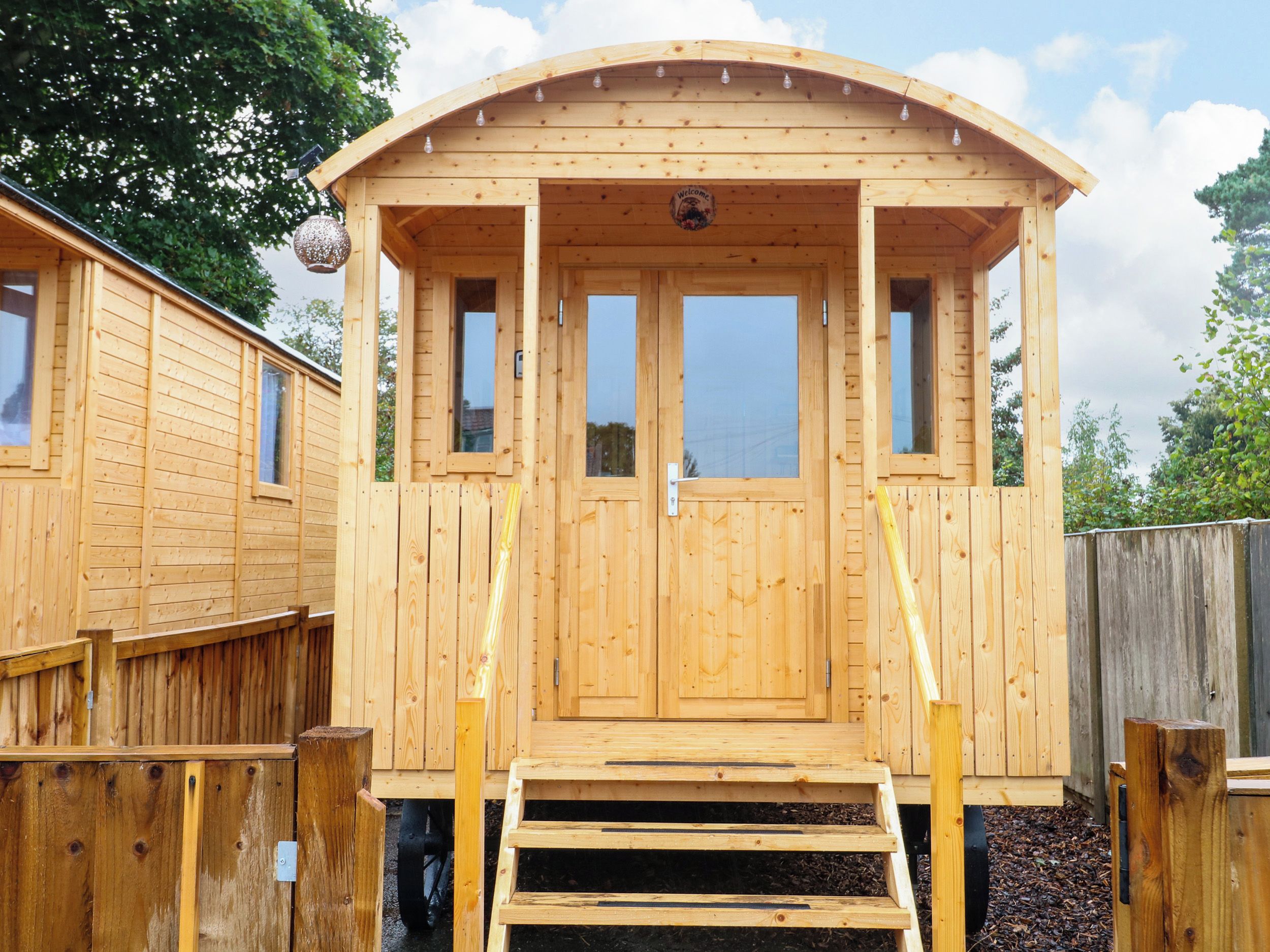 A wooden cabin with a curved roof, a door, and a window.