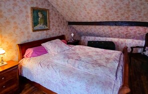 A bedroom with a bed, a nightstand, a lamp, a dresser, a chair, and a painting on the wall. - Maison de charme en campagne (Lanarce)
