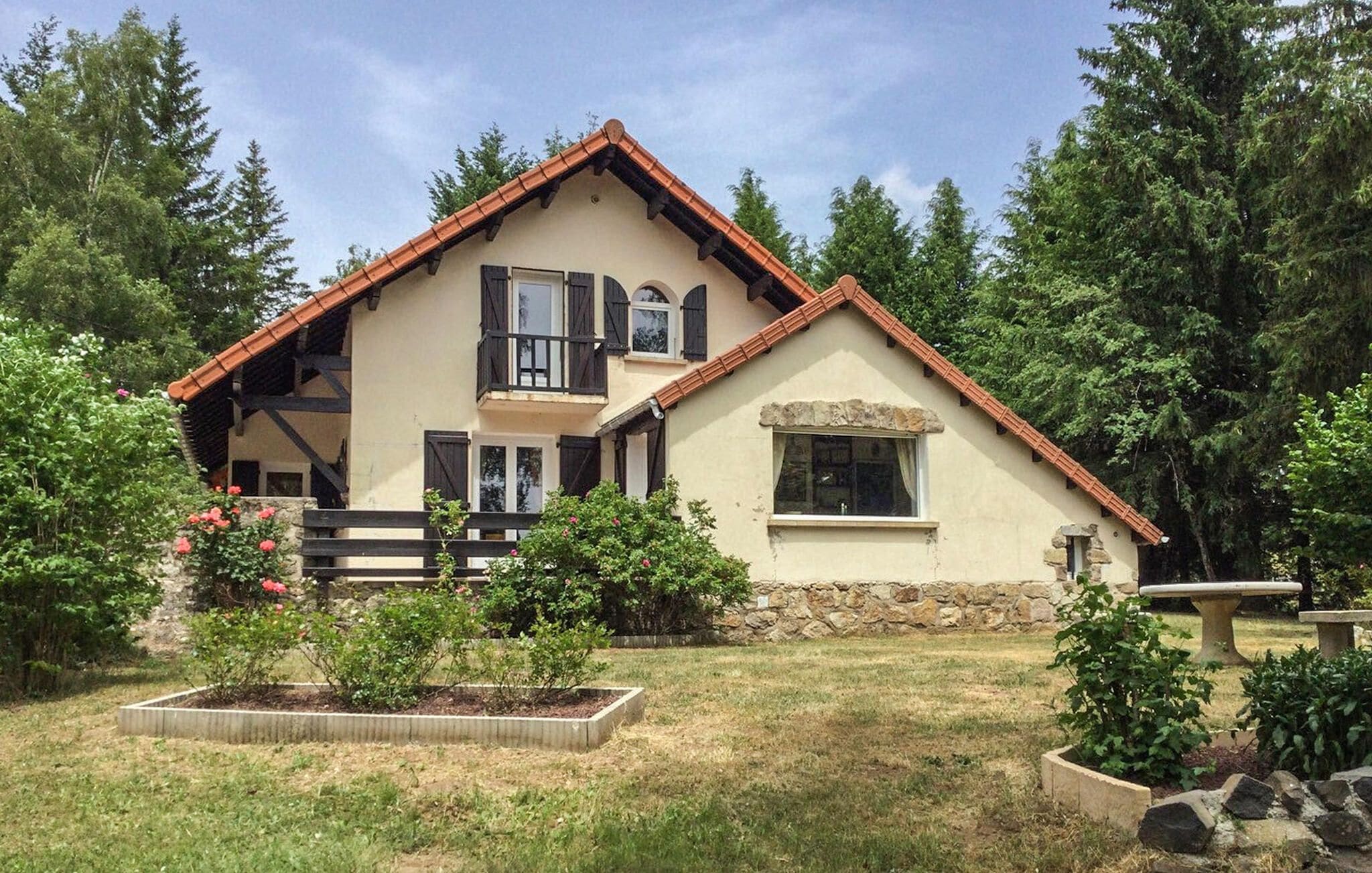 A two-story house with a stone foundation, a red-tiled roof, and a small balcony.