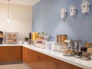 Ein Frühstücksbuffet mit verschiedenen Speisen und einer Kaffeestation.