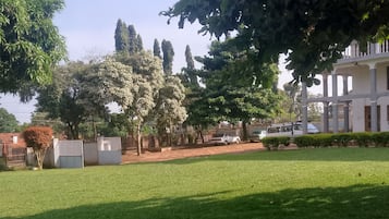 A grassy area with trees and a building in the background.