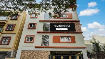 En bygning med flere etager, med et skilt der siger 'TOWNHOUSE Company-Serviced'.