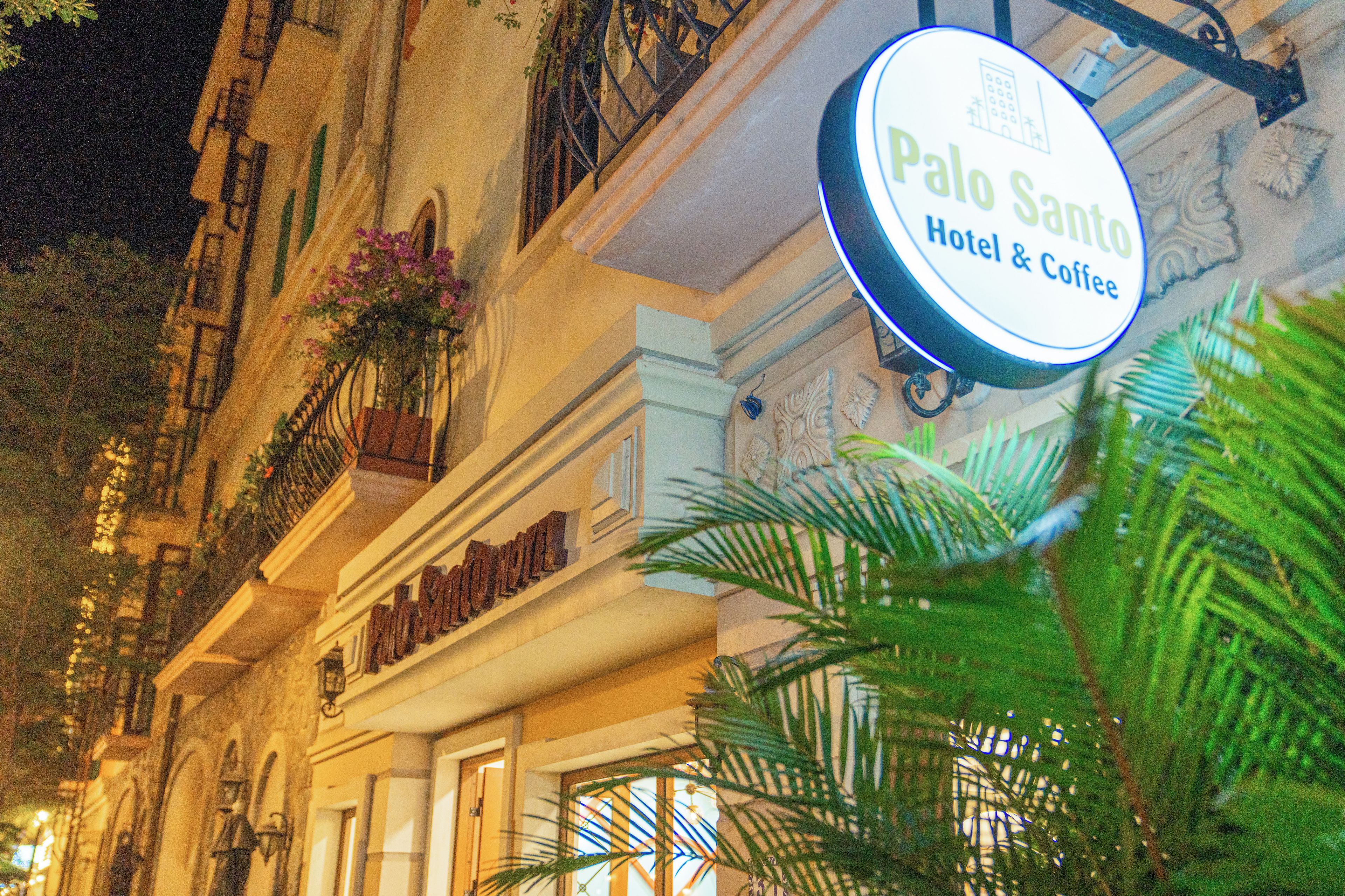 A hotel sign with 'Palo Santo Hotel & Coffee' written on it.