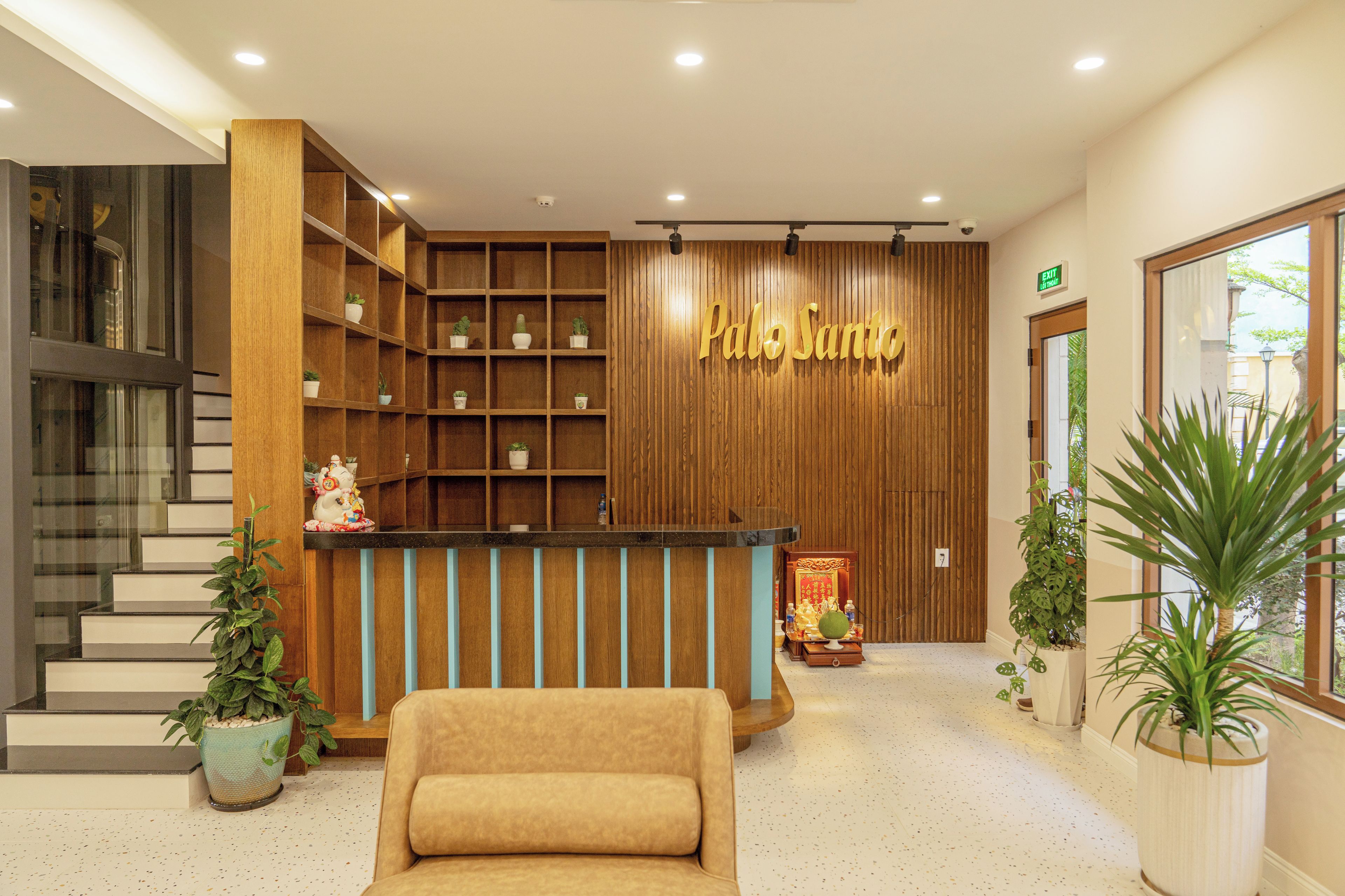 Una zona de recepción con un mostrador de madera, un sofá y plantas en macetas.