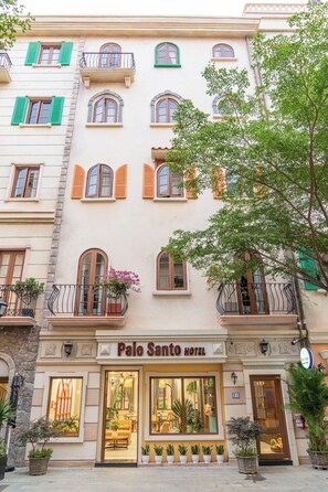 A hotel facade with multiple balconies, large windows, and a sign reading 'Palo Santo Hotel'. - Palo Santo Phu Quoc - Fireworks & Ocean (Phu Quoc)