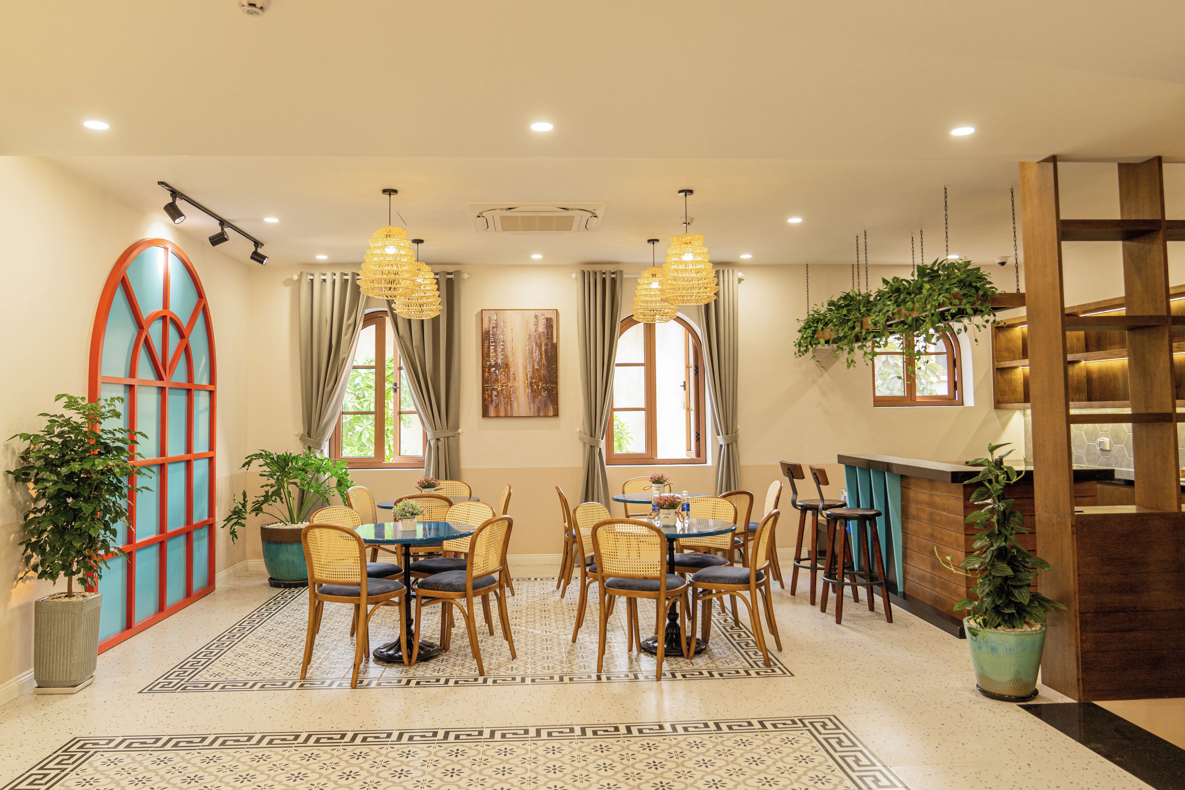 A dining area with a round table, chairs, and hanging light fixtures.