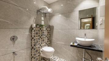 Un baño moderno con inodoro, lavamanos y ducha.