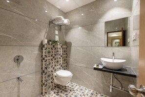 Un baño moderno con inodoro, lavamanos y ducha.