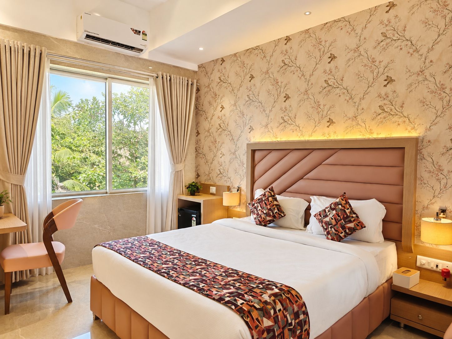Una habitación de hotel con una cama grande, un escritorio, una silla y una ventana con cortinas.