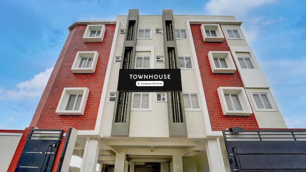 A multi-story building with a sign indicating 'TOWNHOUSE' and 'Company-Served' services. - Townhouse Svb Tech Park Kalapatti (Coimbatore)