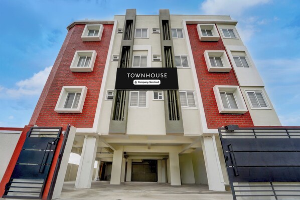 A multi-story building with a sign indicating 'TOWNHOUSE' and 'Company-Served' services. - Townhouse Svb Tech Park Kalapatti (Coimbatore)