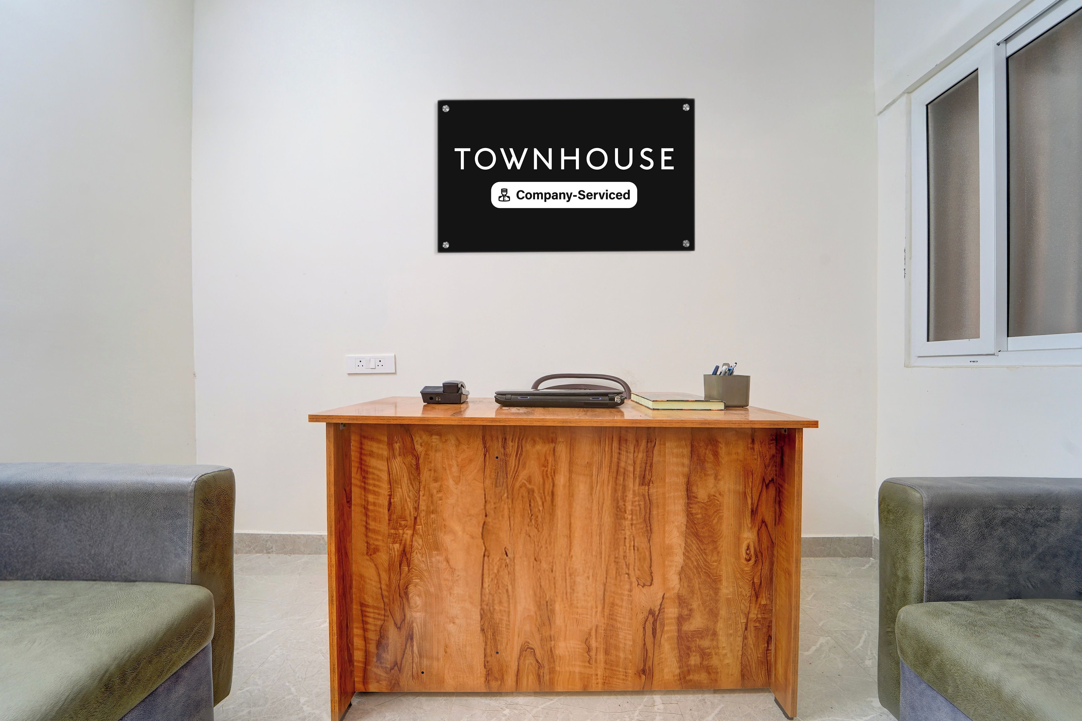 Una mesa de recepción con un cartel que dice 'TOWNHOUSE Company-Serviced'.