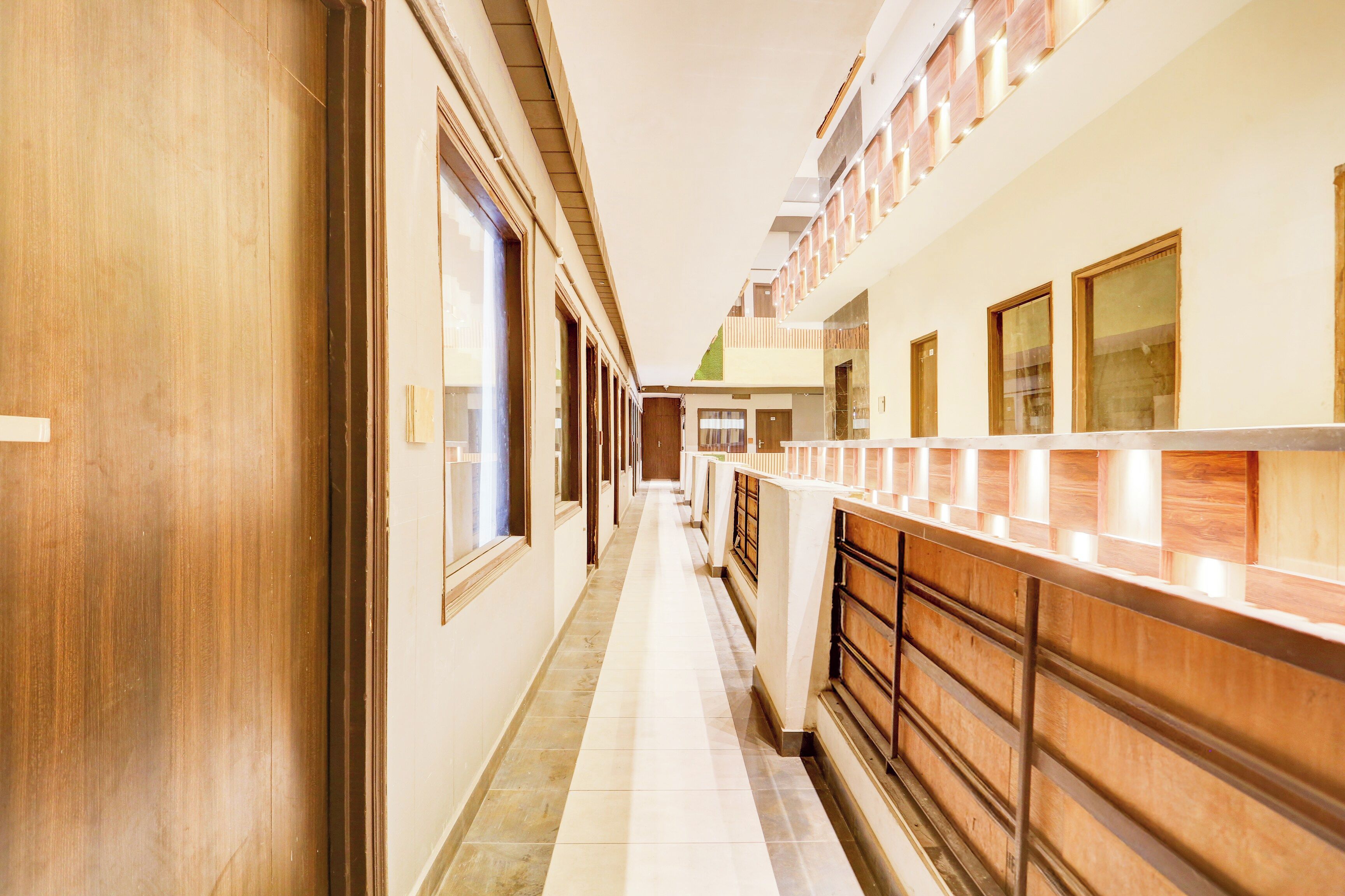 A hotel corridor with wooden doors, a reception desk, and a tiled floor.
