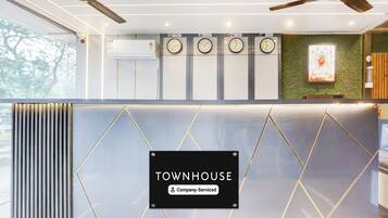 Zona de recepción con un letrero que dice 'TOWNHOUSE Company Serviced'.