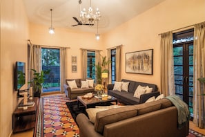 A spacious living room with a sofa set, a coffee table, and a chandelier.