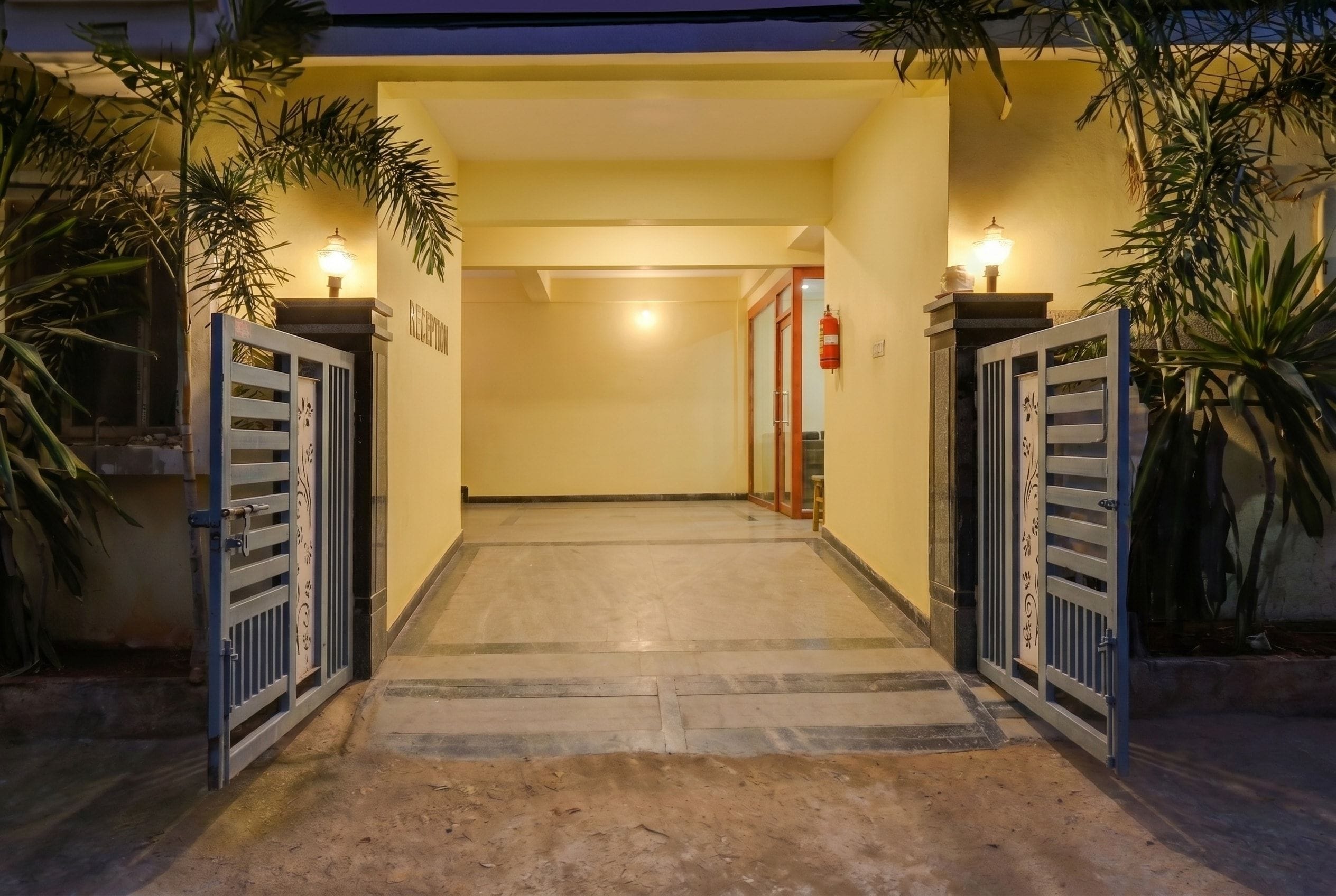 Uma área de recepção com piso de azulejos, balcão de atendimento e uma porta que dá para outro espaço.