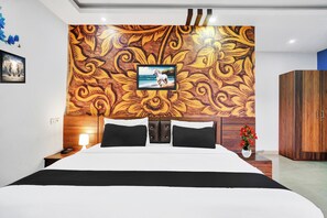 Une chambre d’hôtel avec un grand lit, une tête de lit ornée d’un motif décoratif, une table de chevet avec une lampe et une armoire en bois.