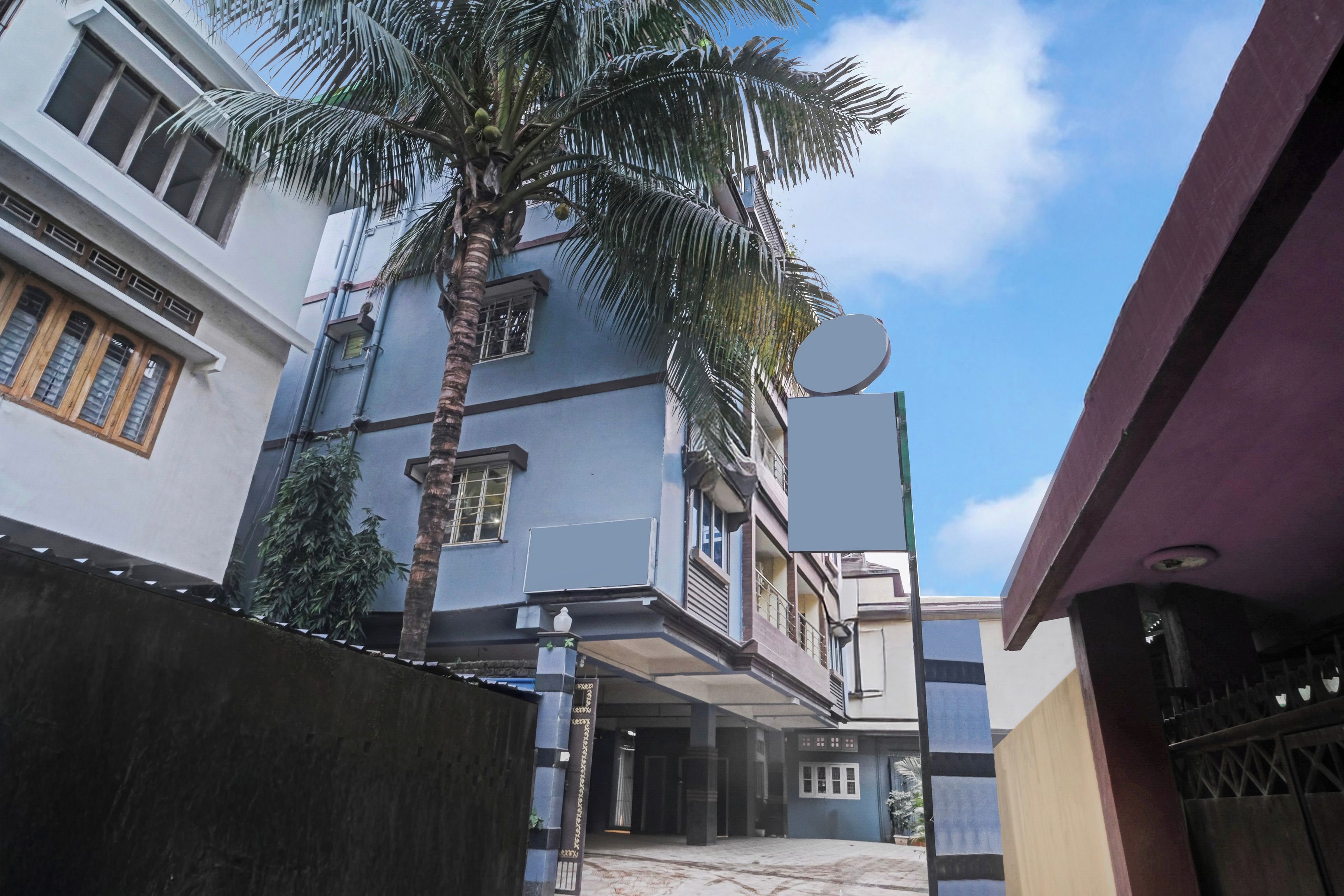 Edifício residencial com um pátio central, uma palmeira e uma antena parabólica.
