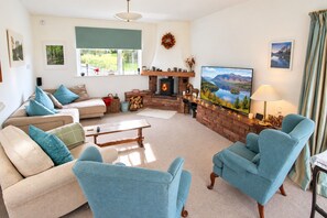 A living room with a fireplace, a television, and a sofa. - Willow Bank, Low Row, bungalow with stunning countryside views to Hadrian's Wall (Low Row)