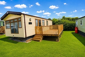 A mobile home with a deck, a nameplate, and a grassy yard. - Calf Lonning Caravan, Plumbland, in a quiet Cumbrian village close to Keswick and Western Lakes (Plumbland)