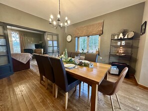 A dining area with a wooden table, chairs, and a chandelier. - Pretty gite with terrace near the Semois river (Alle-sur-Semois)